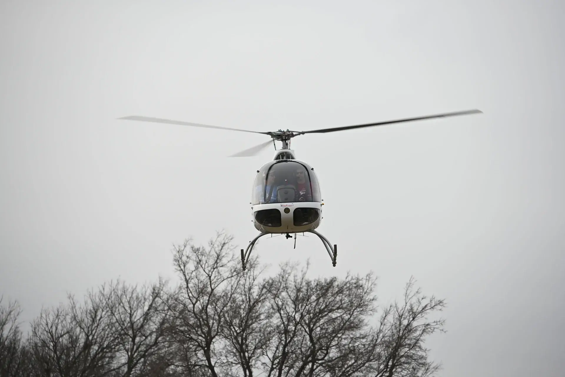 Guimbal Cabri G2 flying over trees during helicopter training