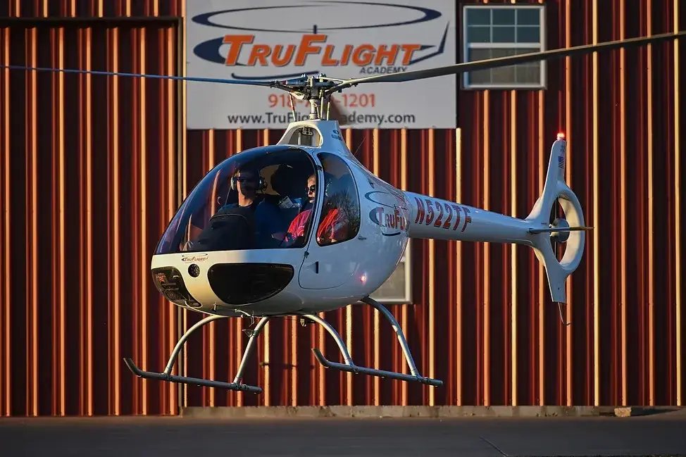 Helicopter hovering with TruFlight logo on wall in the background
