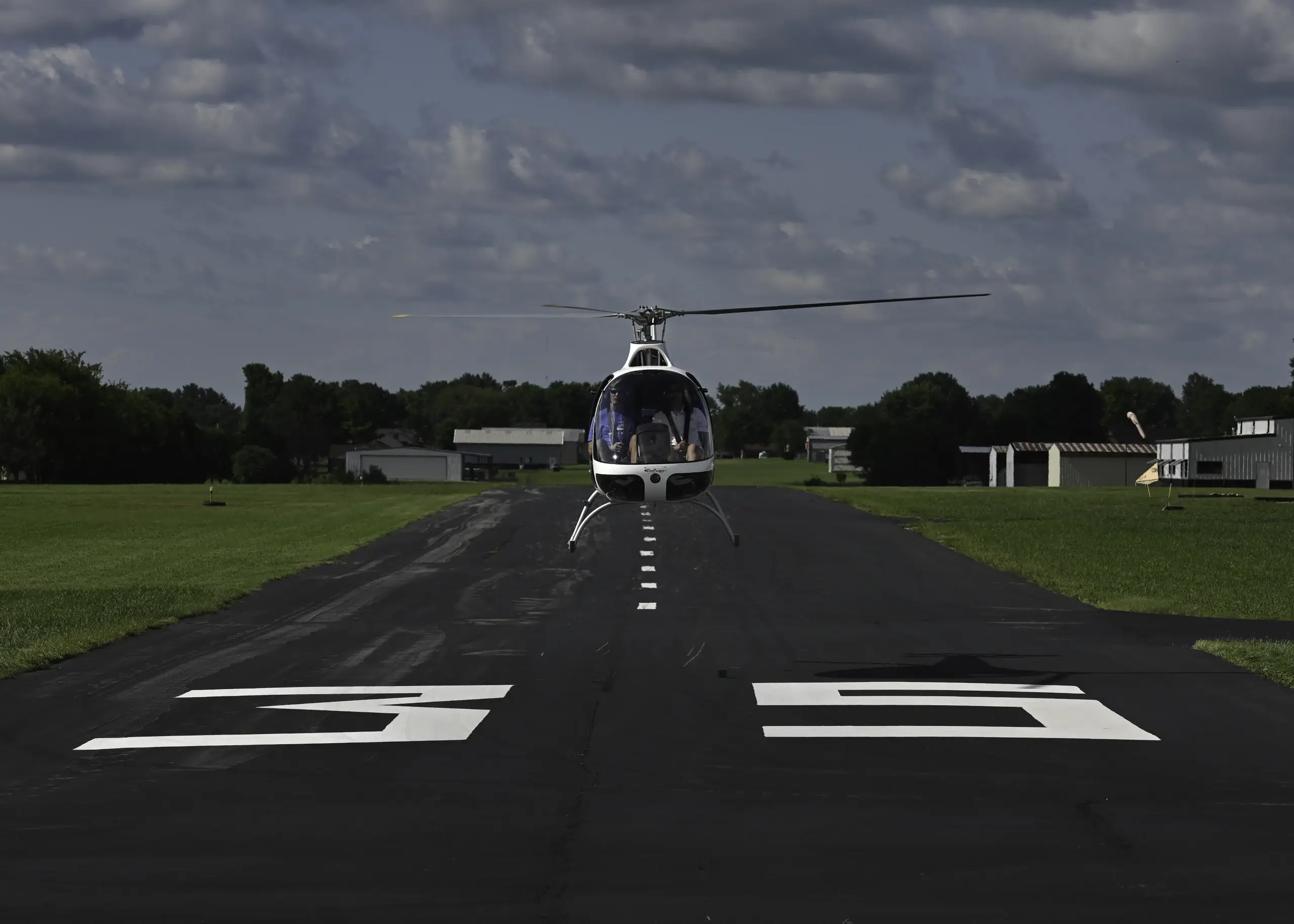 Front view of helicopter taking off over runway