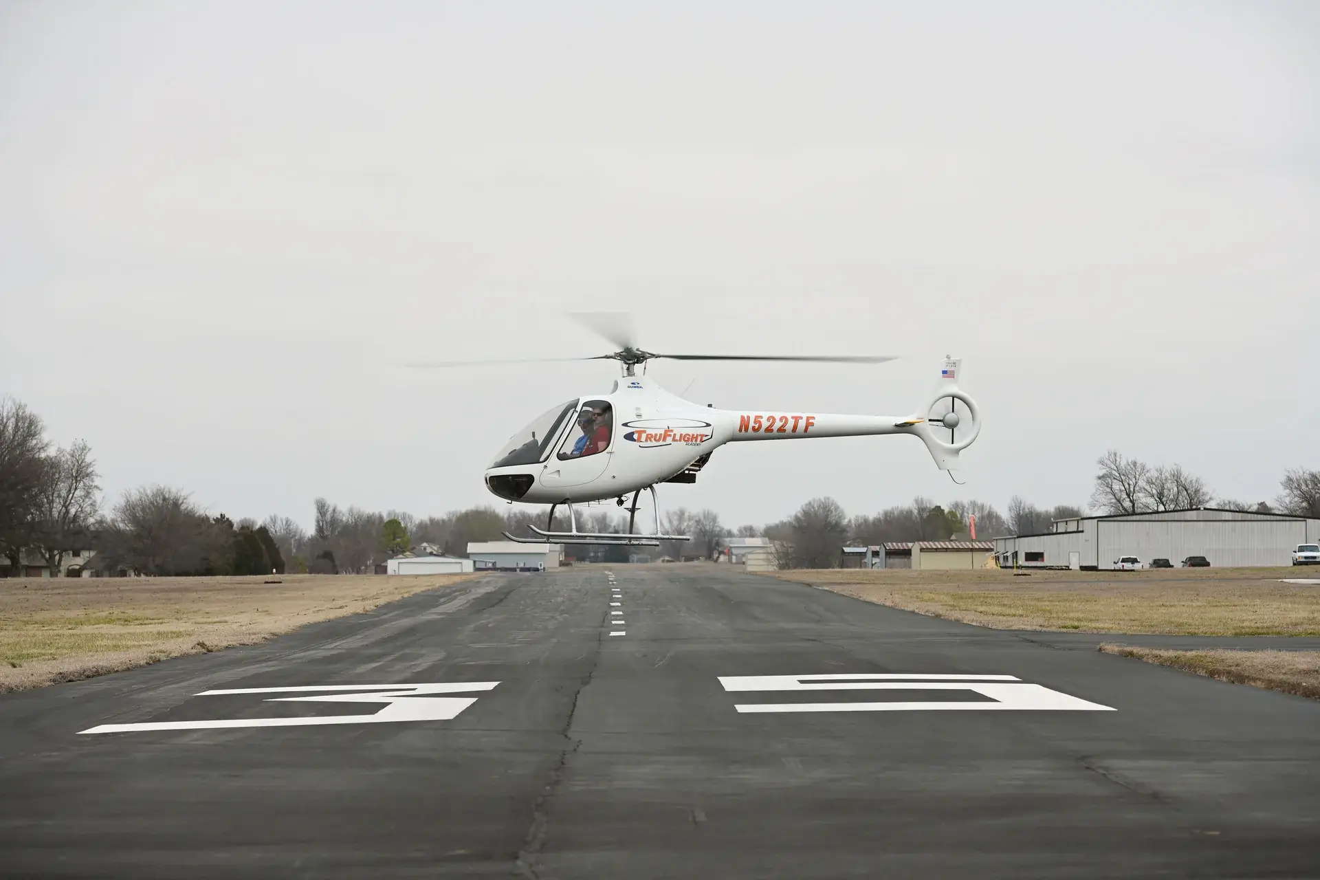 Helicopter flying with trees in the background