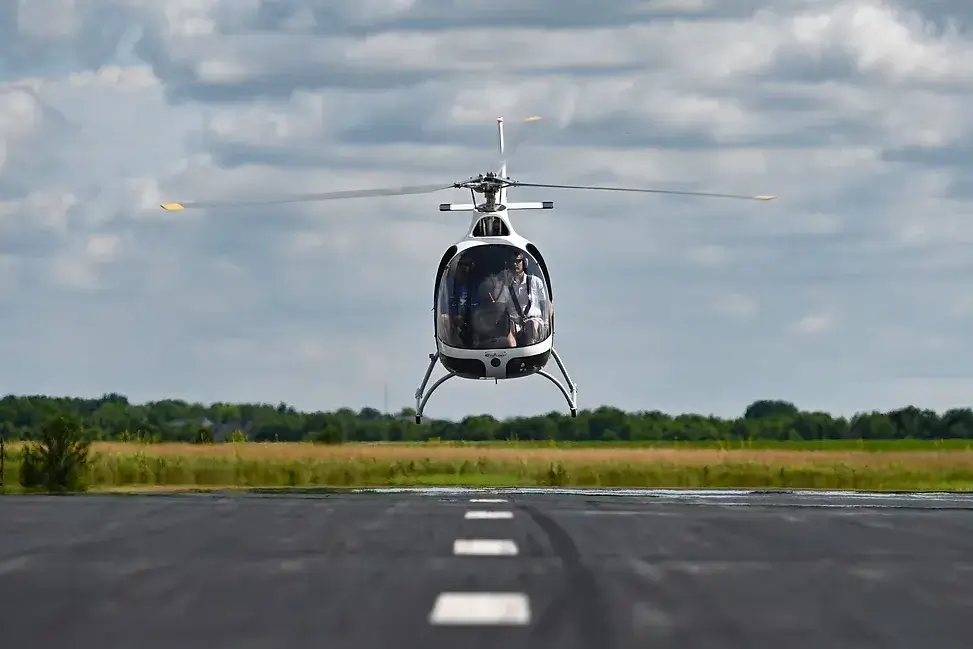 Front low angle view of an helicopter taking off in a runway